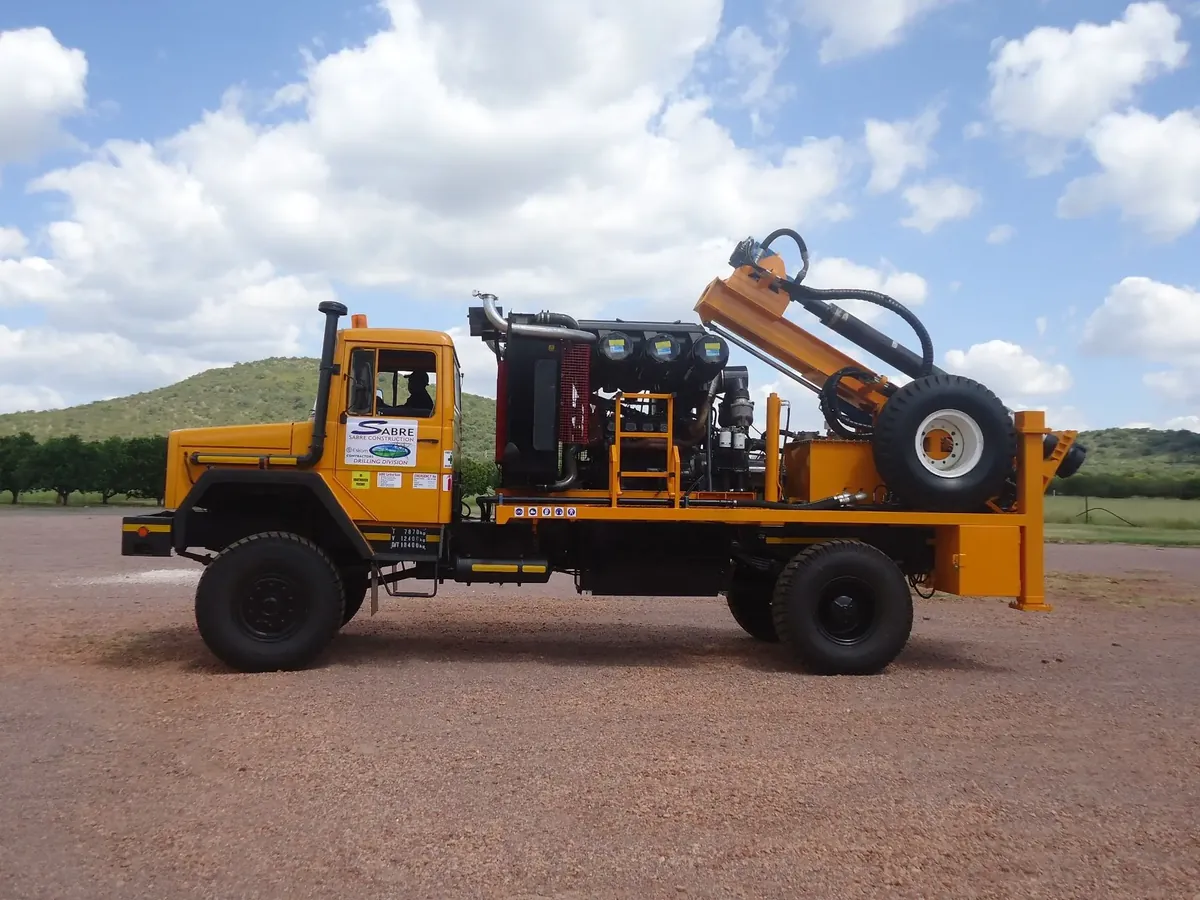 Refurbished truck-mounted borehole drilling rig with onboard compressor, rebuilt by Drillbuilders