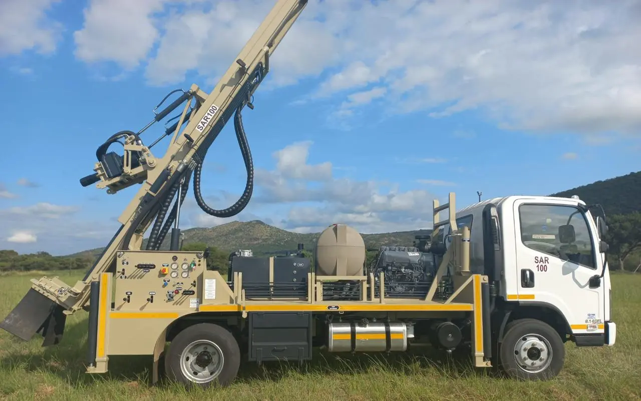 Truck-mounted SAR100 water well drill rig with compact mast operating in the field.