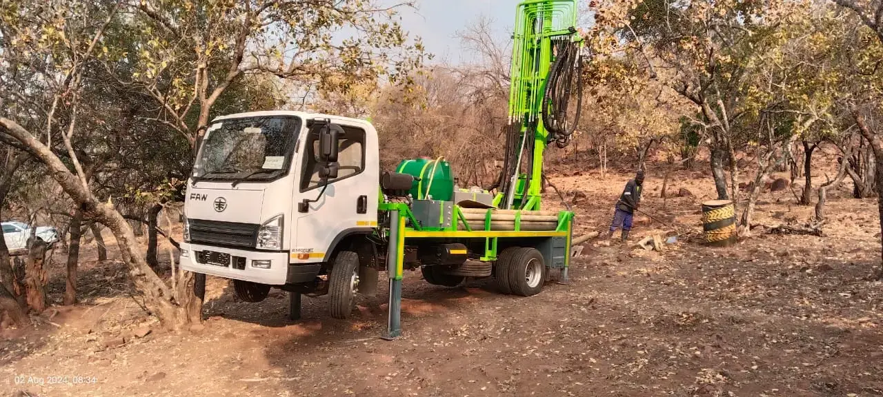 Truck-mounted SAR100 water well drill rig with compact mast operating in the field.