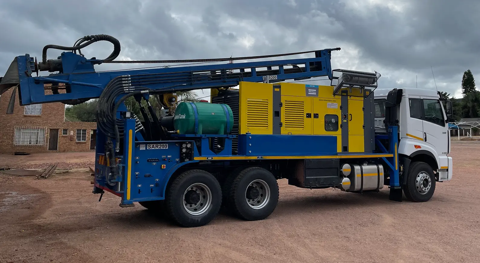 Heavy-duty SAR200 truck drill rig with 15-ton pullback and tall mast for deep well drilling.