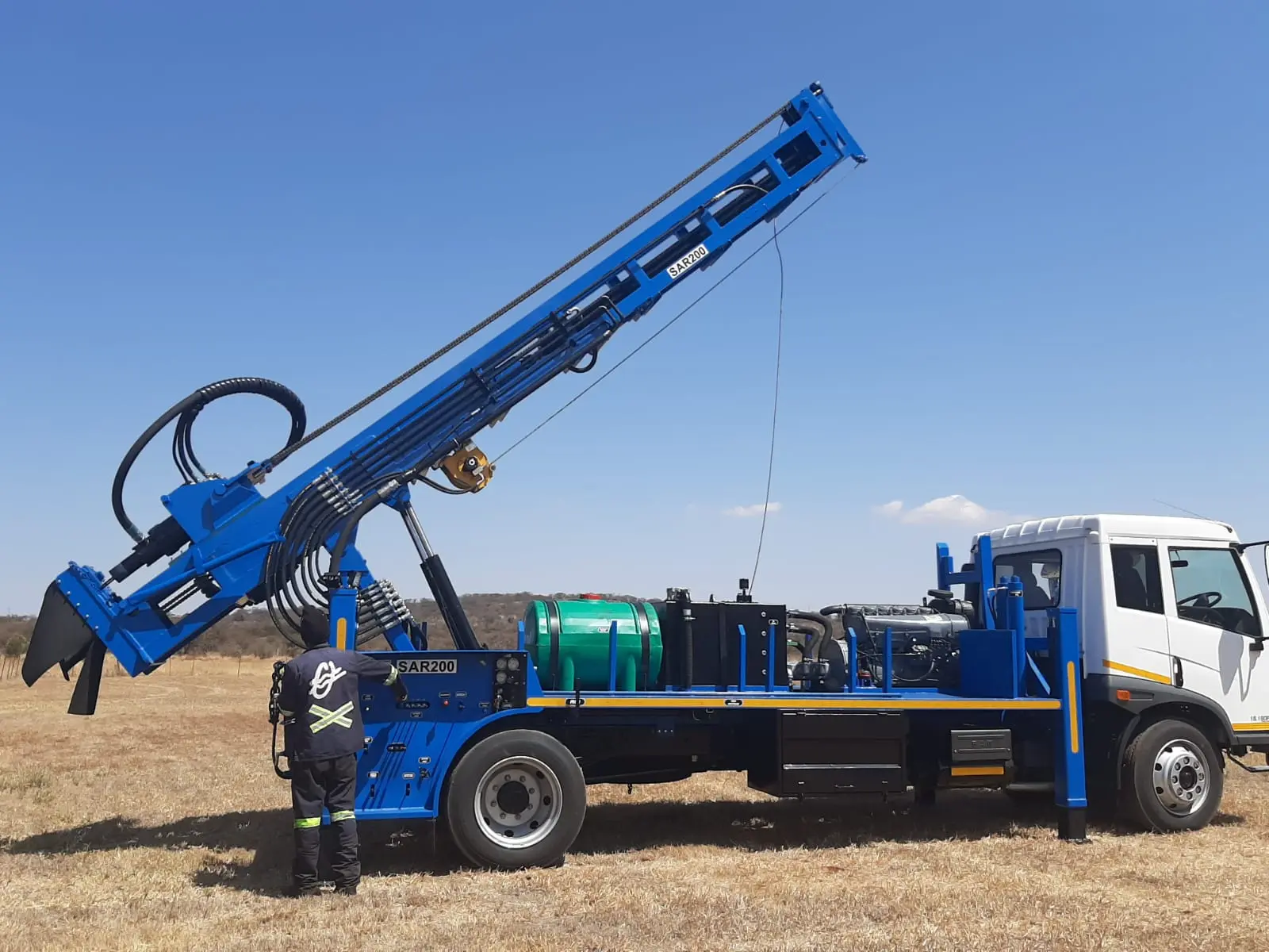 Heavy-duty SAR200 truck drill rig with 15-ton pullback and tall mast for deep well drilling.