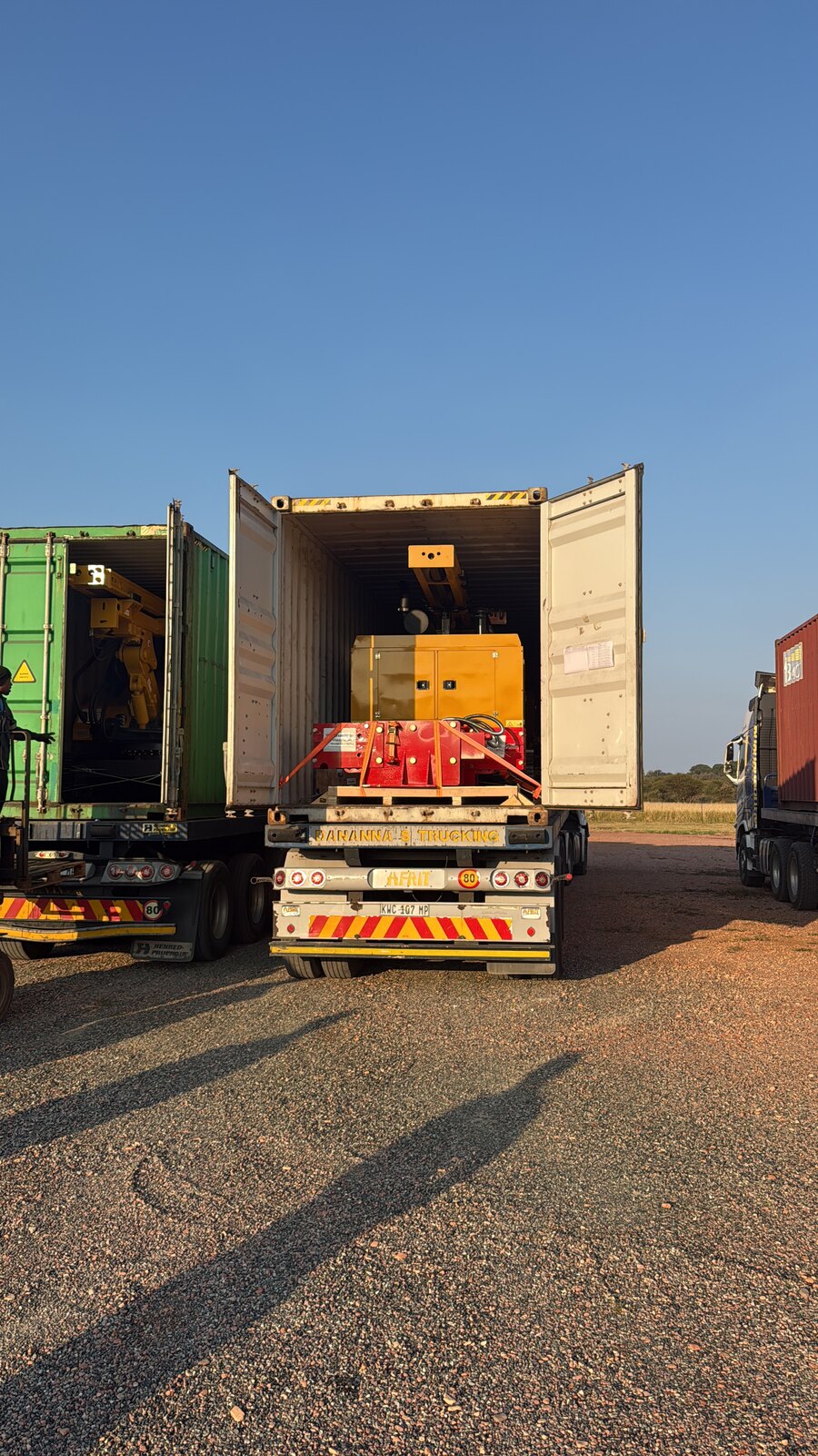 Line of flatbed trucks carrying shipping containers arriving at the Drillbuilders yard in Mokopane