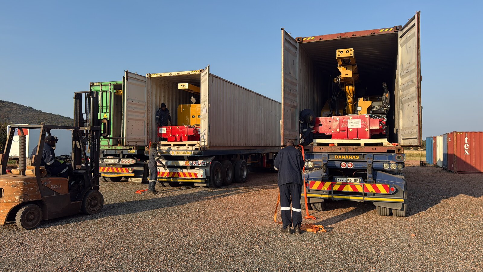 Forklift easing a solar piling rig out of its shipping container at the Drillbuilders yard